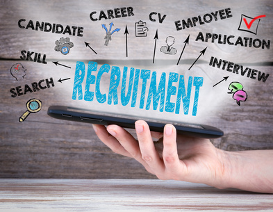 Recruitment Concept. Tablet computer in the hand. Old wooden background.
